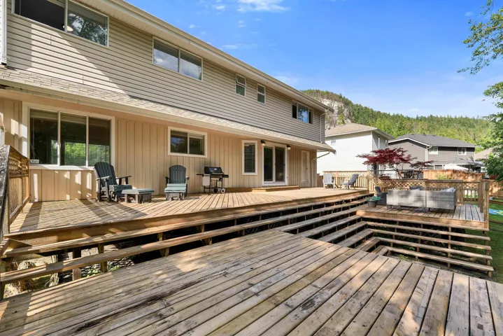 Multi-level wood deck featuring a tiered design, multiple outdoor living areas, and a built-in spa
