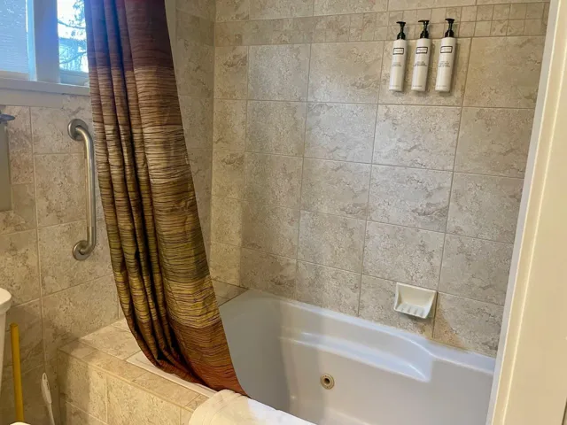 Bathroom featuring a combined bath / shower with jetted tub