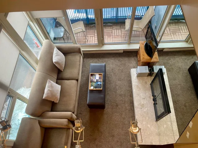 Carpeted living area with healthy amount of natural light and baseboard heating