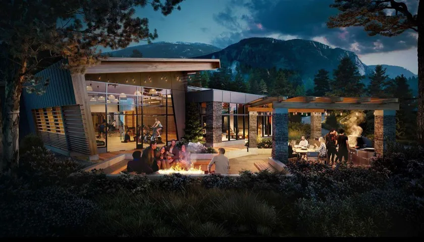 Back of house at night with an outdoor fire pit, stone siding, and a deck with mountain view