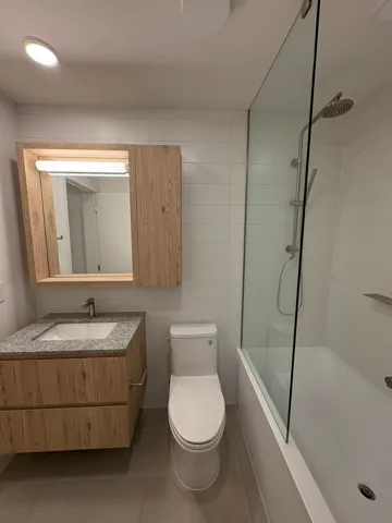 Bathroom featuring tile walls, vanity, tiled shower / bath, and tile patterned floors