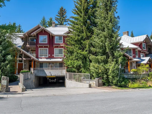View of front of home featuring a chimney, an attached garage, and driveway