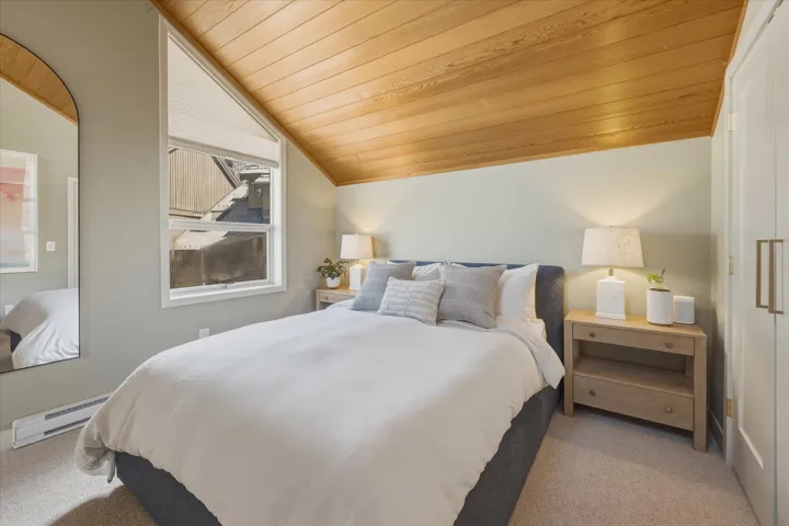 Sloped wood-paneled ceiling with recessed lighting