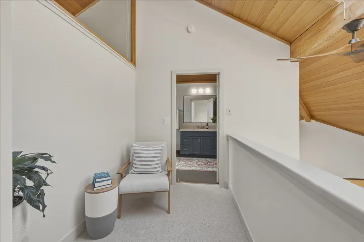 Second-story landing featuring a vaulted wood-paneled ceiling with a ceiling fan