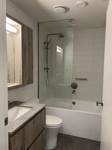 Full bath featuring vanity, dark tile patterned floors, and shower / bathtub combination