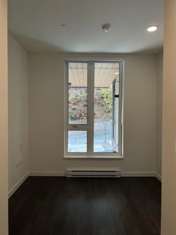 Spare room with dark wood-type flooring, a baseboard radiator, and recessed lighting