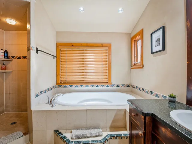 Bathroom with vanity, a garden tub, tiled shower, and recessed lighting