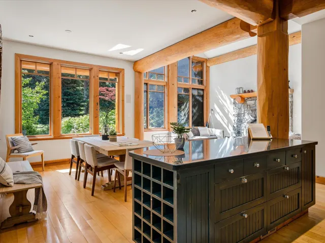 Dining space featuring light wood-style flooring, a skylight, and beamed ceiling