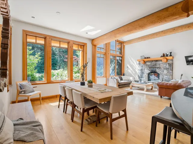 Dining area featuring light wood-type flooring, beamed ceiling, a fireplace, and a skylight