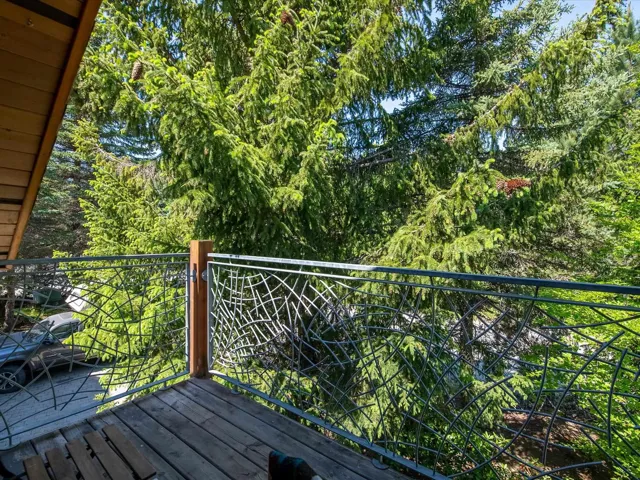 Balcony featuring view of wooded area