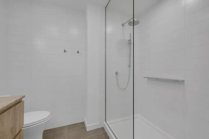 Full bath featuring walk in shower, vanity, tile walls, and tile patterned floors