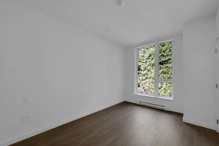 Spare room featuring dark wood-style flooring and a baseboard heating unit