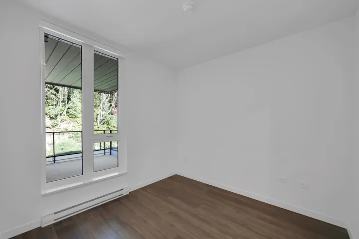 Spare room featuring baseboard heating and dark wood finished floors