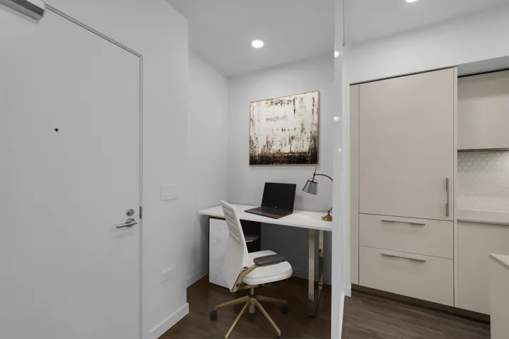 Office with wood finished floors and recessed lighting