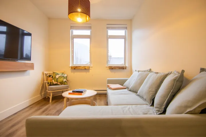 Sitting room with wood finished floors and a baseboard heating unit
