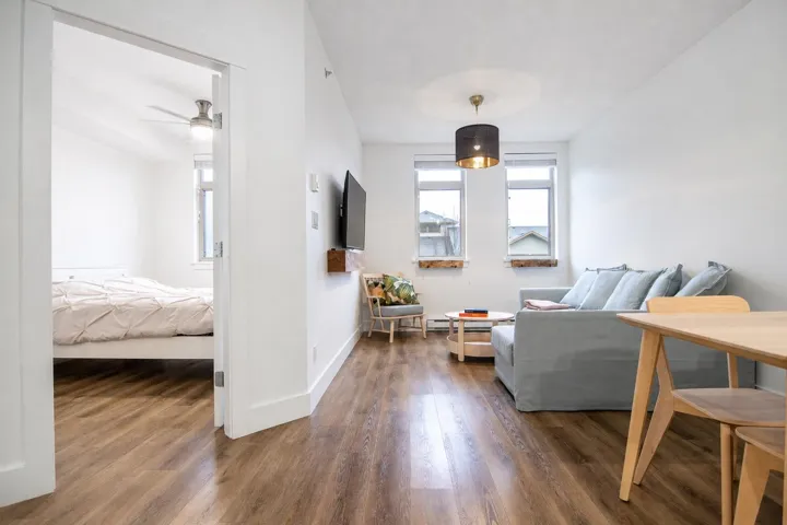 Open concept living area featuring wood-finish flooring, white walls, and recessed lighting