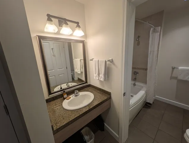 Full bathroom with shower / bath combo with shower curtain and dark tile patterned floors