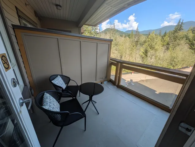 Balcony featuring a wooded view and a mountain view