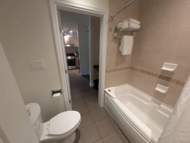 Full bath with light tile patterned floors and shower / bath combo with shower curtain