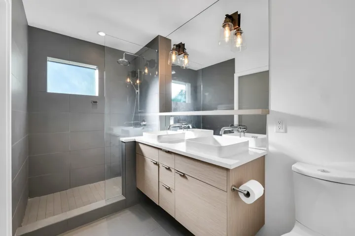 Bathroom featuring walk in shower, double vanity, and plenty of natural light