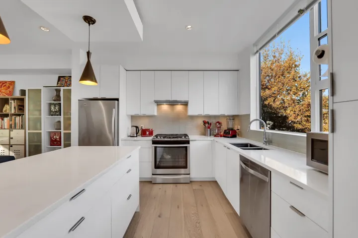 Kitchen with modern cabinets, stainless steel appliances, tasteful backsplash, white cabinets, and recessed lighting
