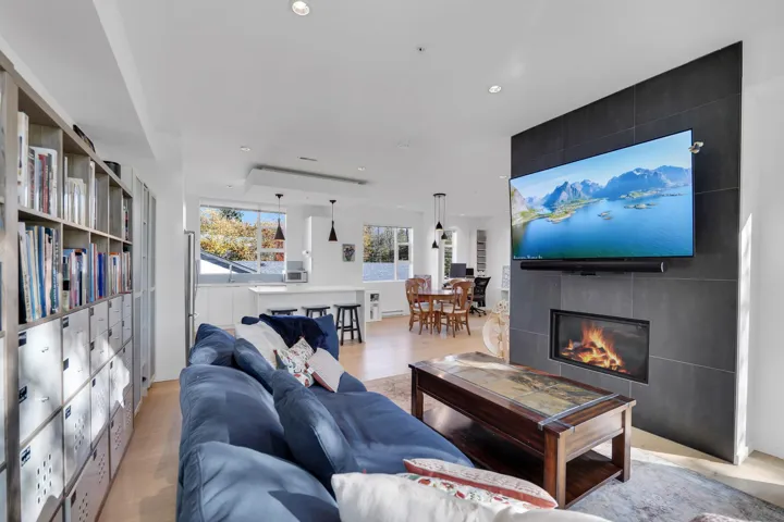 Living room with a fireplace, wood finished floors, and recessed lighting