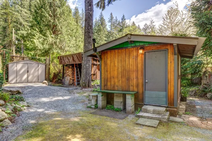 Wood-sided outbuilding with a metal door and a small exterior light fixture