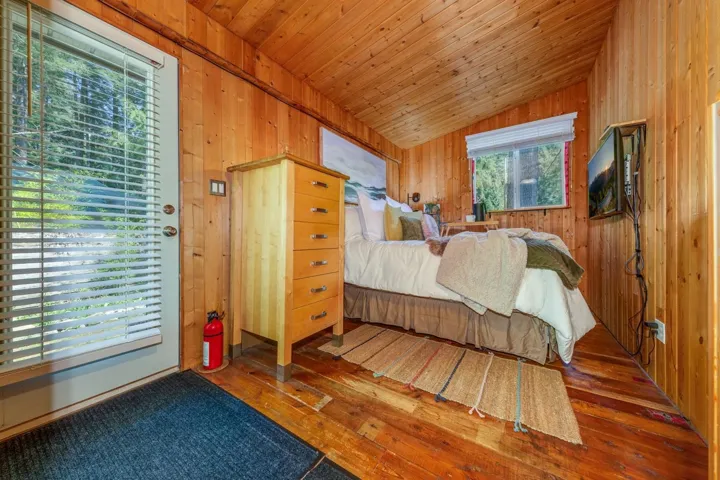 Wood-paneled room featuring an angled ceiling and wood-finish flooring