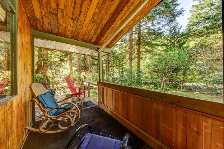Covered porch featuring a wood-paneled ceiling and walls