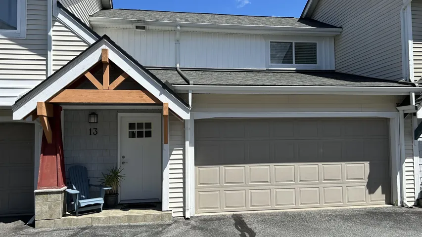 Exterior featuring a covered entryway with exposed wood beams, a shaker-style front door with window panes, and horizontal siding