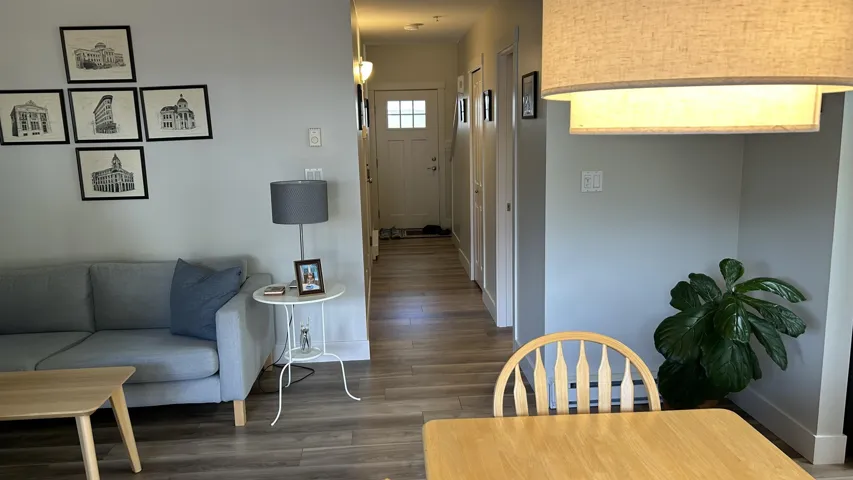 Open-concept living space featuring wood-finish flooring, light gray wall paint, and a built-in ceiling light fixture