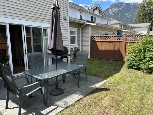 Rear patio with brick pavers and surrounding lawn