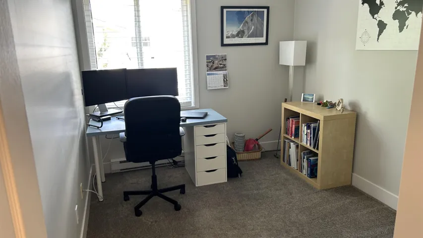 Well-lit room featuring light gray wall paint, white trim, and neutral-toned carpeting