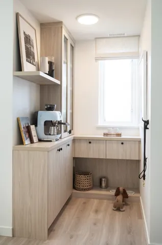 Custom built-in cabinetry with light wood-finish doors and dark hardware, complemented by a floating shelf