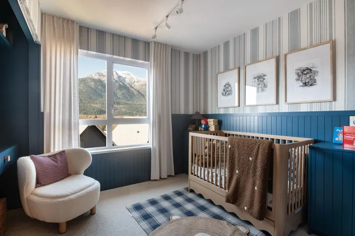 Room with a large window featuring mountain scenery
