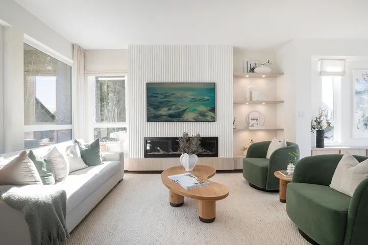 Living area with a contemporary fireplace featuring a vertical slat surround and wood-finish base