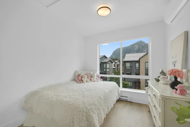 Bedroom featuring an AC wall unit, light wood-style flooring, and a baseboard radiator
