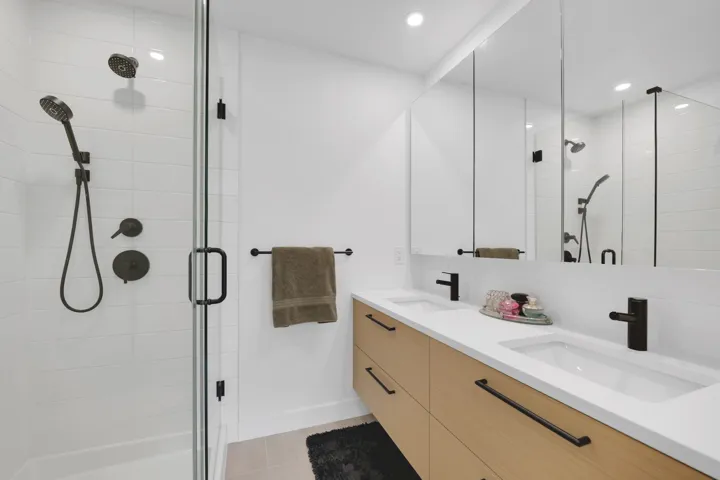 Full bath featuring double vanity, a shower stall, tile patterned floors, and recessed lighting