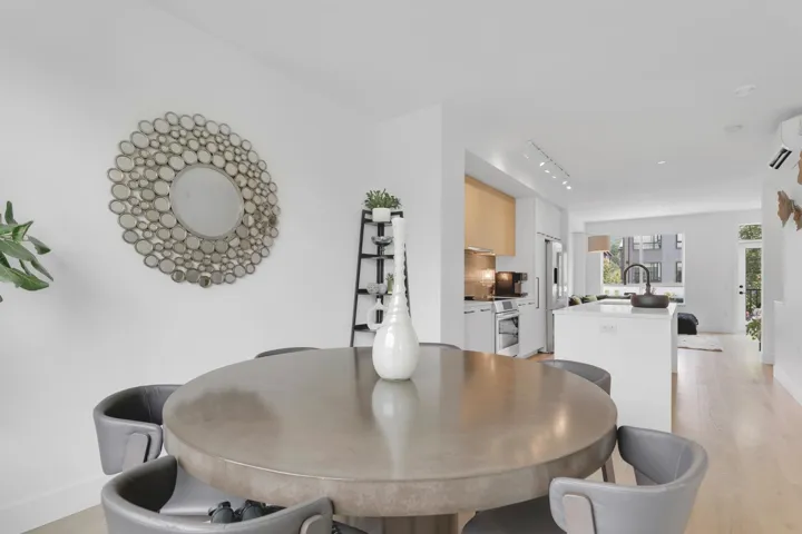 Dining room featuring light wood-style flooring, rail lighting, and a wall unit AC