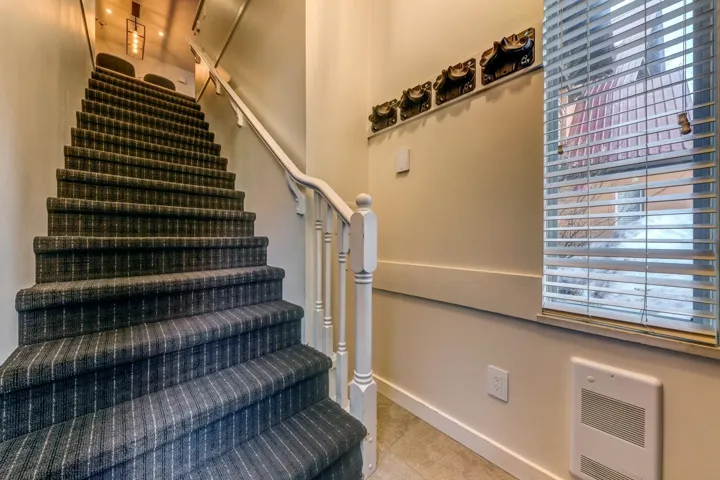 Staircase featuring heating unit and baseboards