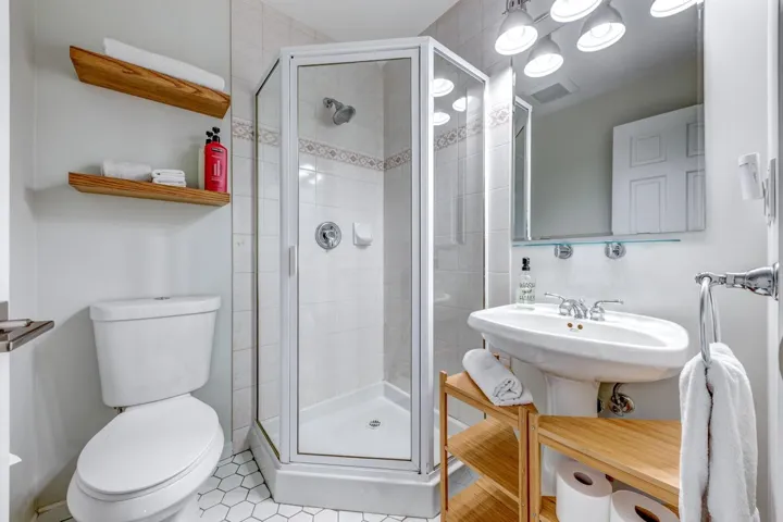 Bathroom featuring visible vents, a shower stall, and toilet
