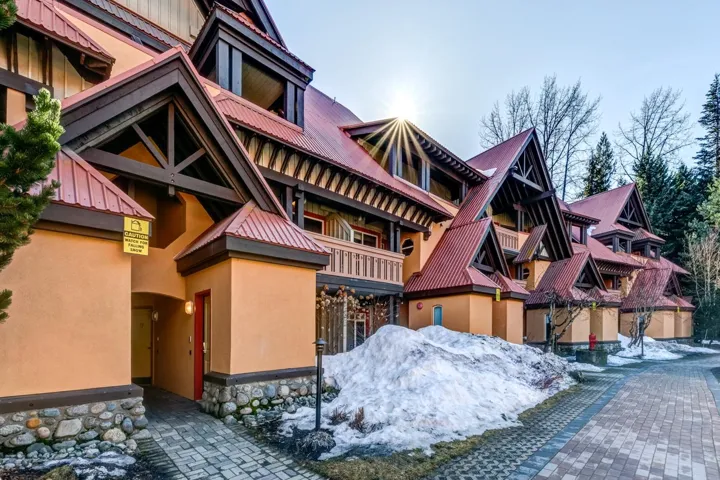 View of front facade with metal roof, stone siding, and stucco siding