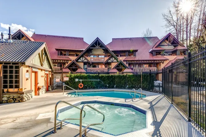 Community pool with fence, a hot tub, and a patio