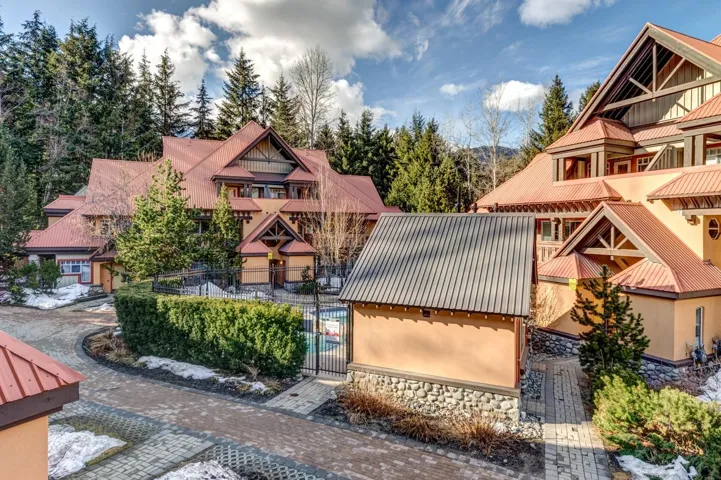 View of front of house with metal roof, fence, and stucco siding