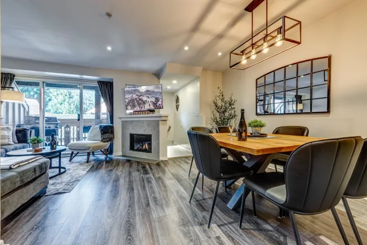 Dining room featuring a glass covered fireplace, wood finished floors, and recessed lighting