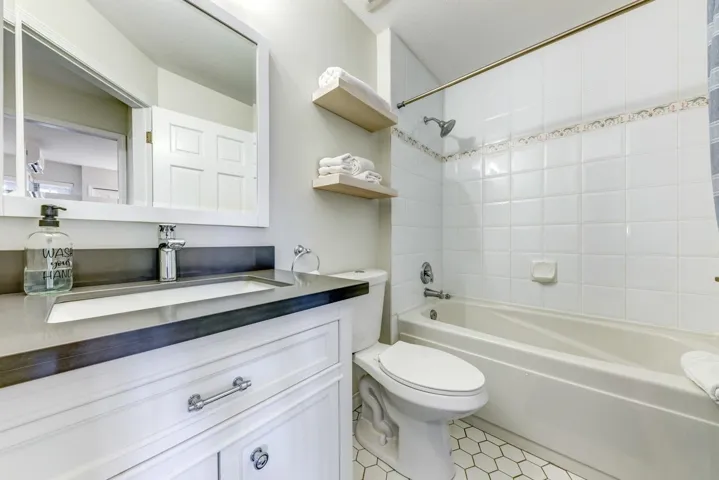 Bathroom with shower / bathing tub combination, vanity, and toilet