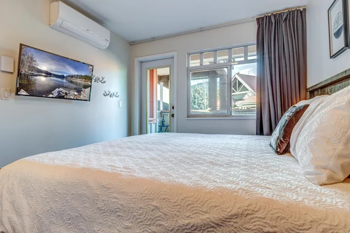 Bedroom with access to outside and a wall unit AC