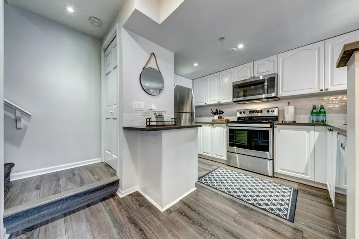 Kitchen with dark countertops, white cabinets, and stainless steel appliances