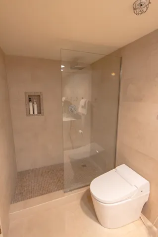 Bathroom with walk in shower and tile walls