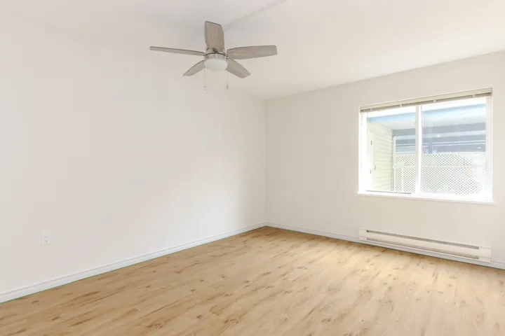 Spare room featuring a baseboard radiator, light wood finished floors, and ceiling fan